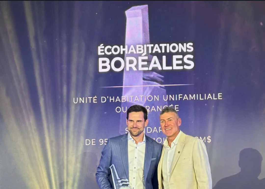 Deux hommes posent avec le trophée devant l'écran du gala des Prix Domus, qui affiche « Écohabitations Boréales » et la catégorie « Unité d'habitation unifamiliale ou en rangée »